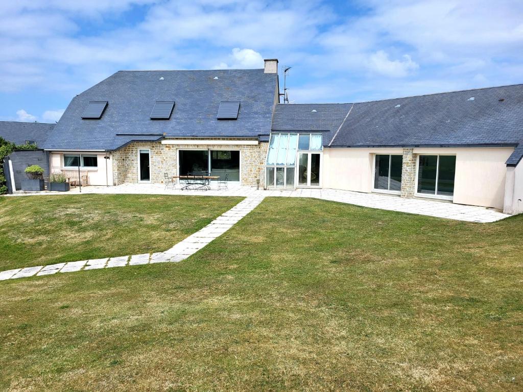 une maison avec une grande cour devant elle dans l'établissement Villa bord de mer La Mielle, à Créances