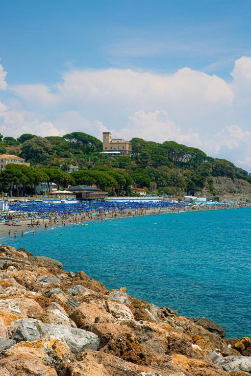 a group of people on a beach near the water at Sea Point in Celle Ligure