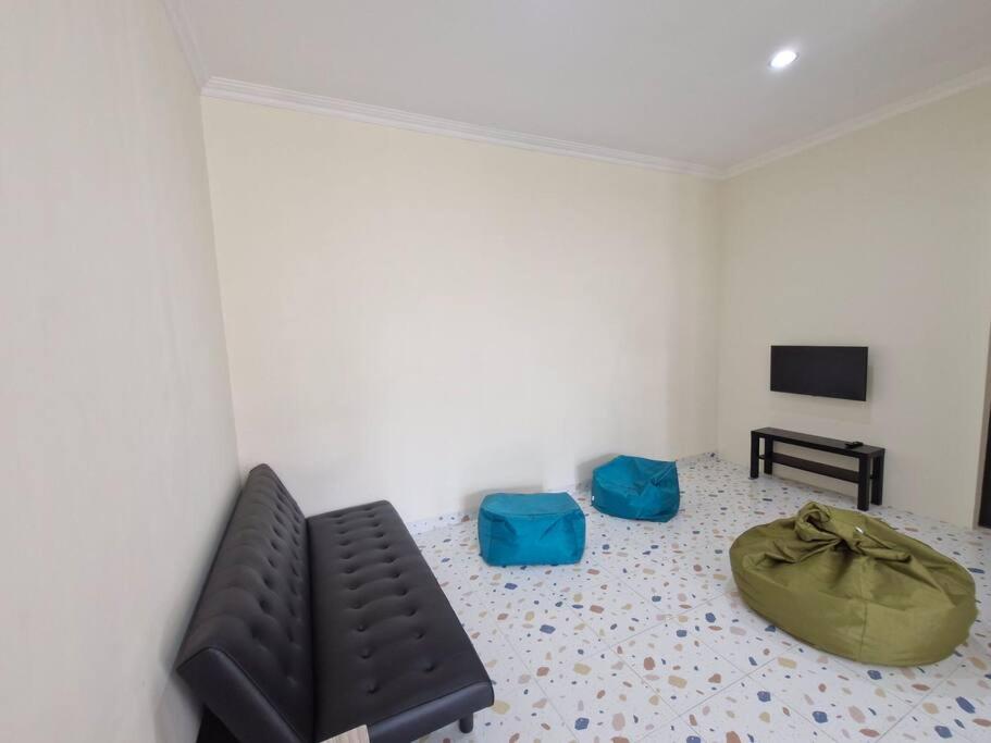 un soggiorno con un divano e una televisione di Guesthouse Jogja Selatan 2 Yogya South-Bantul Casa de Joy a Gandok