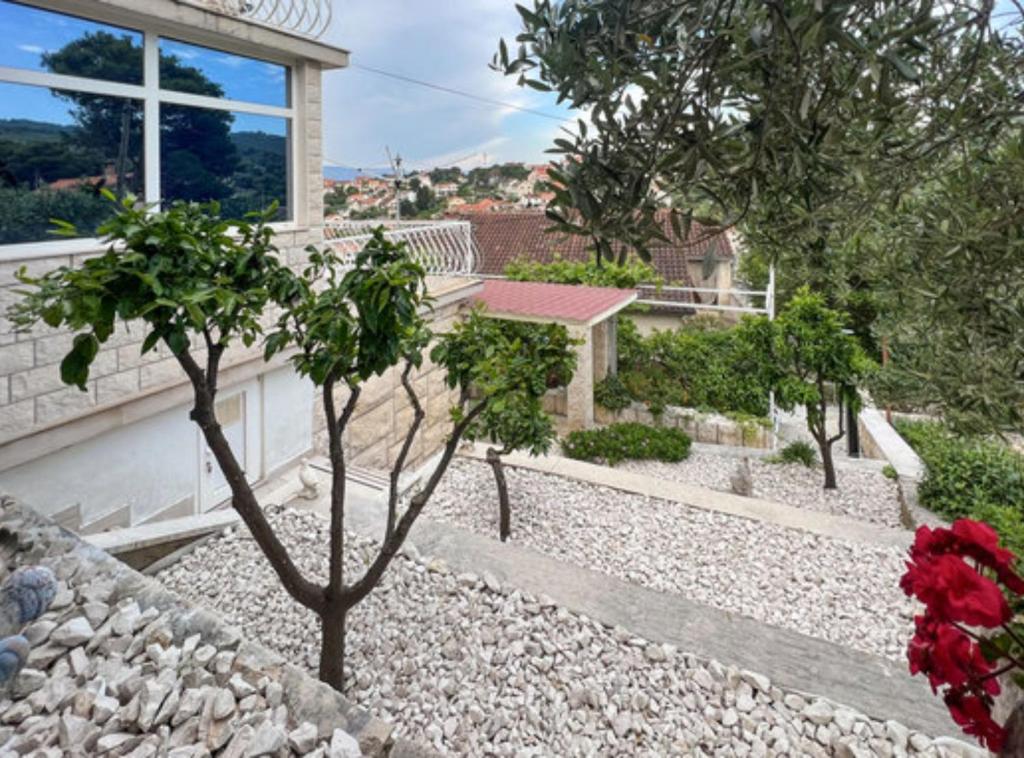 a garden with rocks and trees and a house at Holiday Home Aurora in Splitska