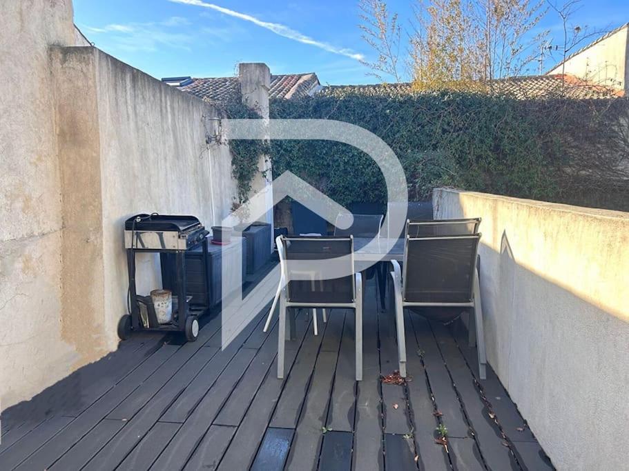 une table et deux chaises assises sur une terrasse dans l'établissement INTRA MUROS - Appartement, à Aigues-Mortes