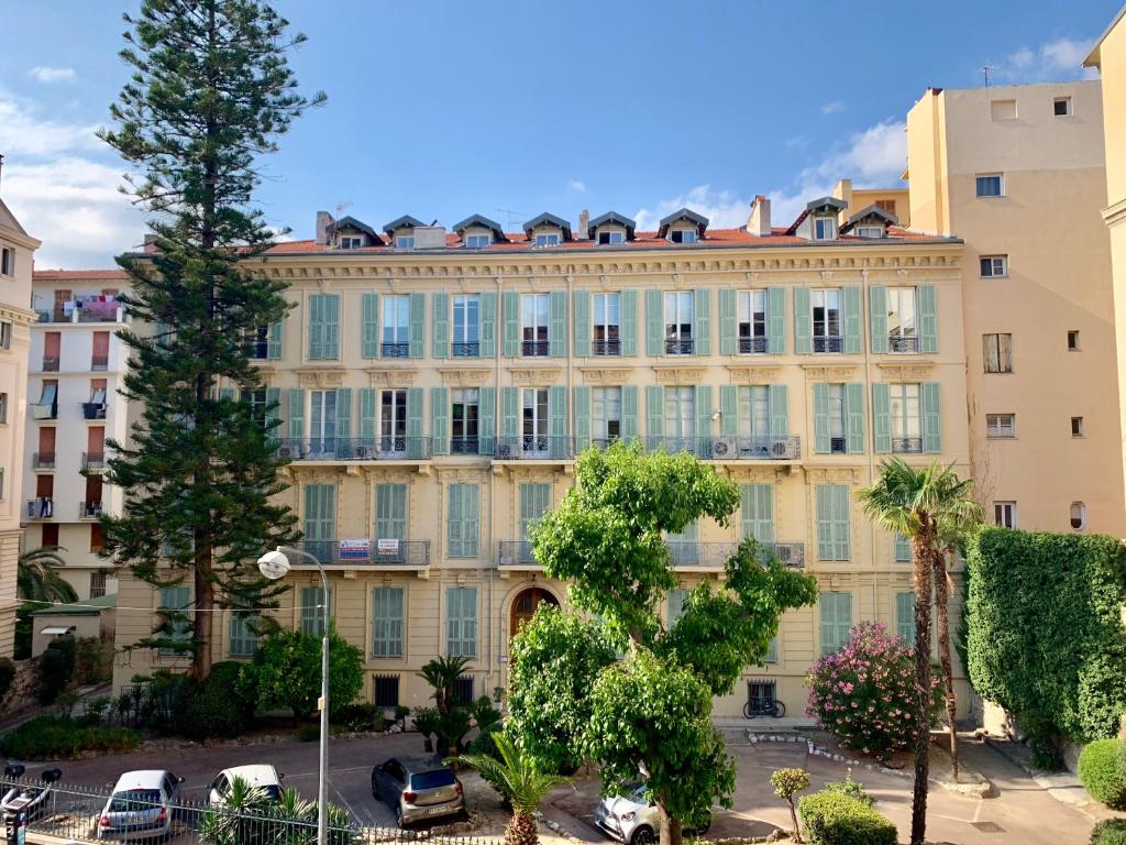 un grand bâtiment avec des voitures garées dans un parking dans l'établissement Appartement niçois au coeur du triangle d'or, à Nice
