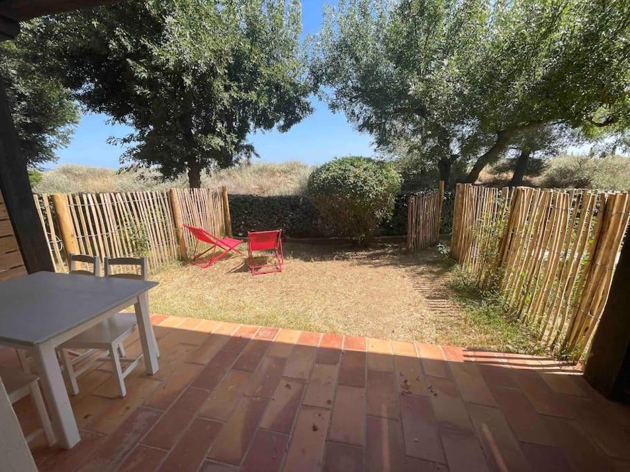 a backyard with a table and a fence at Jolie studio sud jardin et parking privatif in Hyères