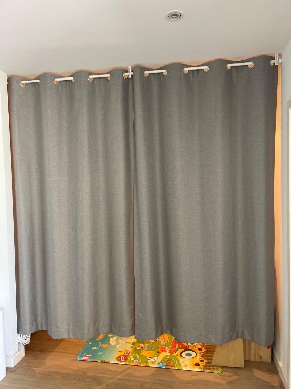 a gray shower curtain in a room with a bed at Glenelg resort style beachside apartment in Glenelg