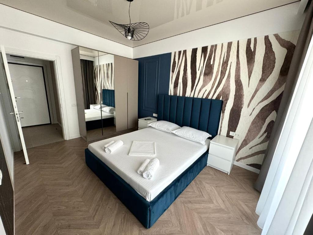 a bedroom with a bed with a blue head board at Nord Residence in Eforie Nord