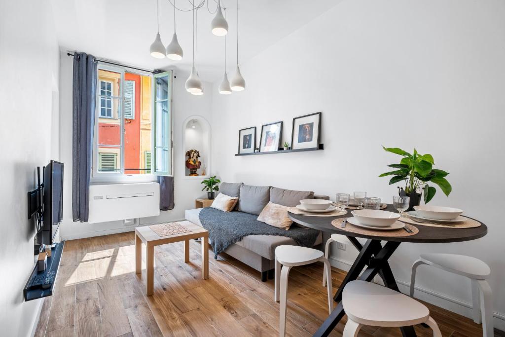 un salon avec une table et un canapé dans l'établissement Nice Renting - ROSSETTI - Modern Haven Heart of Old Nice, à Nice
