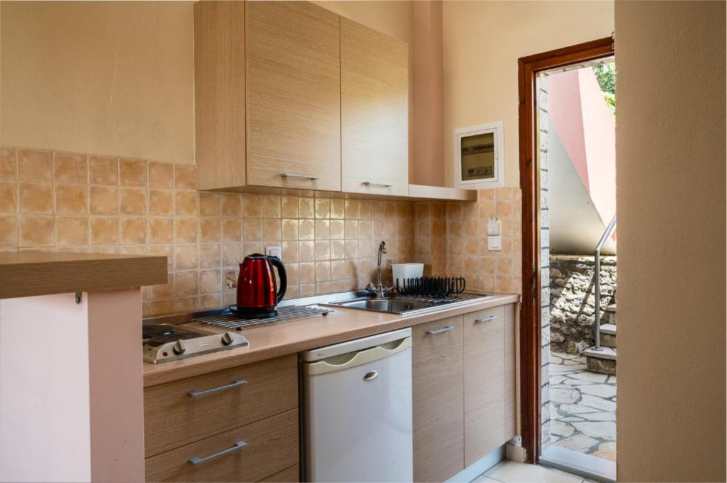 a kitchen with a sink and a counter top at Marietta's Resort by Konnect, Gouvia Corfu in Gouvia