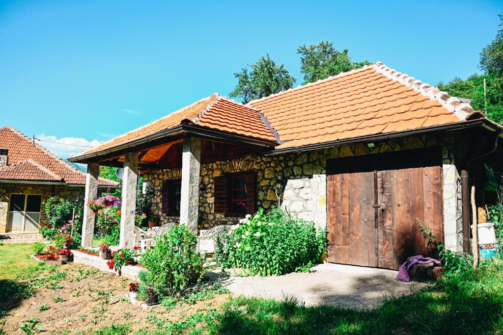 a small house with a wooden door in a yard at Kužina in Plav