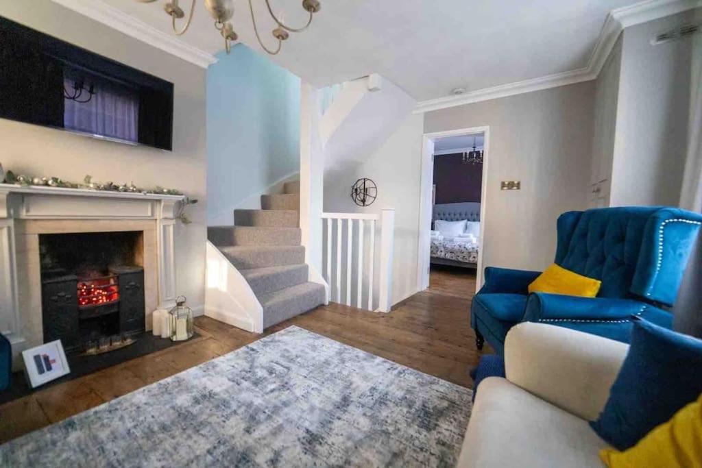 a living room with a blue couch and a fireplace at Stunning City centre Georgian townhouse - parking in Chester