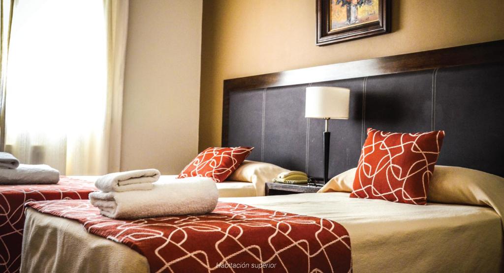 a hotel room with two beds and a large headboard at Hotel Premier in San Miguel de Tucumán
