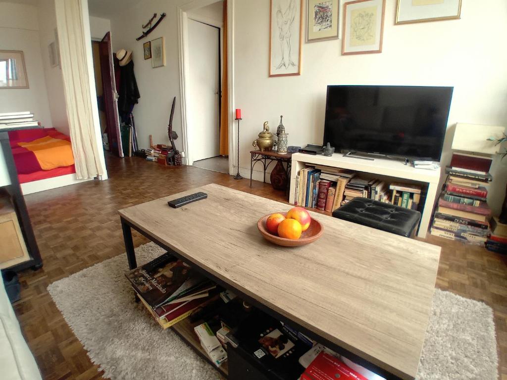 - un salon avec un bol de fruits sur une table basse dans l'établissement jolie studio à paris 12 em, à Paris