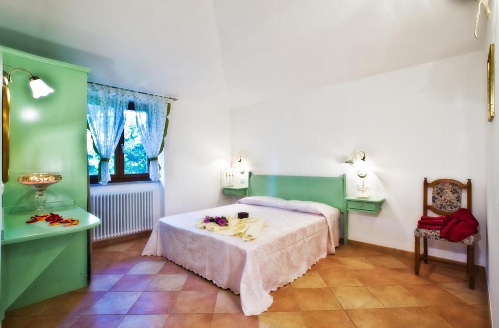 フィアーノ・ロマーノにあるAffittacamere Le Querceのベッドと花が飾られたテーブルのある寝室
