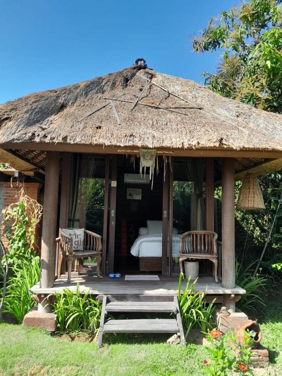 a small hut with two chairs and a bed at Ketewel Bed & Breakfast Yoga Room in Ketewel