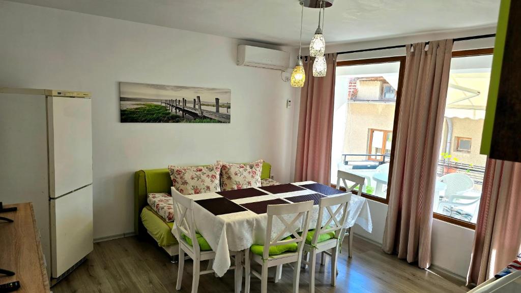 a living room with a table and a green couch at Grand Apartment Pomorie in Pomorie