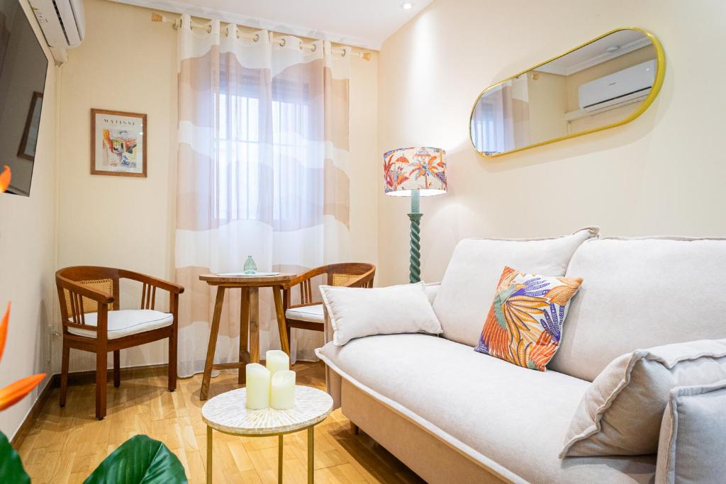 un salon avec un canapé et une télévision au mur dans l'établissement Encantador apartamento céntrico en Barrio Salamanca, junto a WiZink Center Movistar Arena y Plaza de Toros Las Ventas, à Madrid