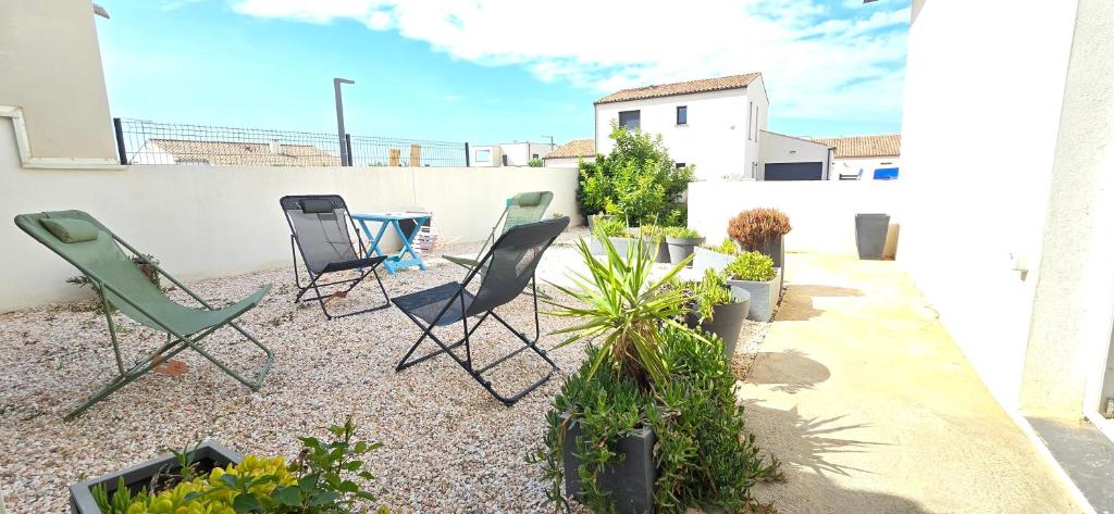 d'une terrasse avec des chaises et des plantes sur un balcon. dans l'établissement Maison 4 chambres lumineuse Proche mer, à Sérignan
