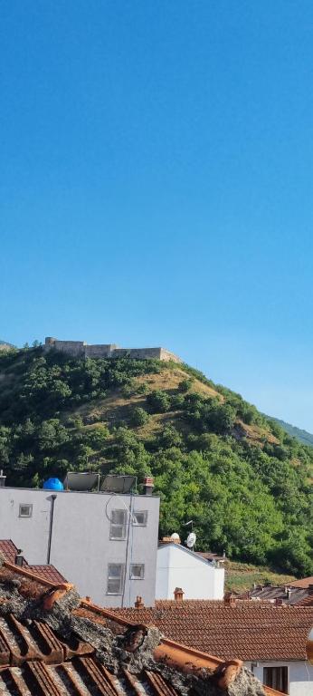 a view of a hill with a white building and roofs at Onur Apartment 's in Prizren
