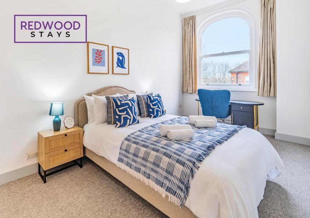 a bedroom with a bed and a blue chair at Comfortable and Homely 1-Bedroom 1-Bathroom Serviced Apartment with Free Parking, Free WiFi By Redwood Stays in Farnborough