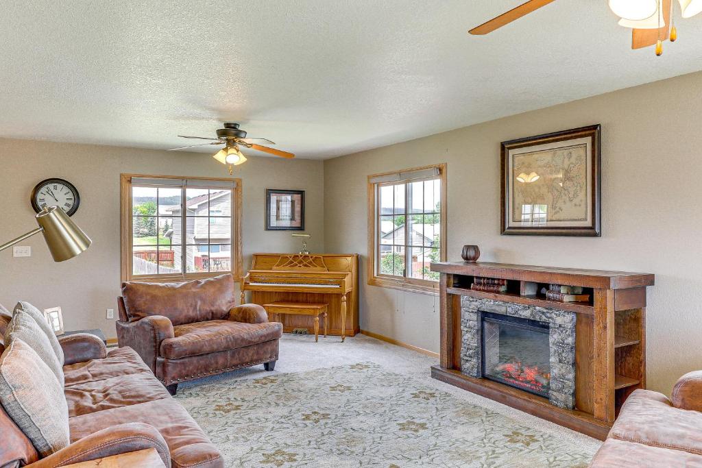 a living room with a fireplace and a piano at Black Hills Family Home Close to Hiking Trails! in Blackhawk