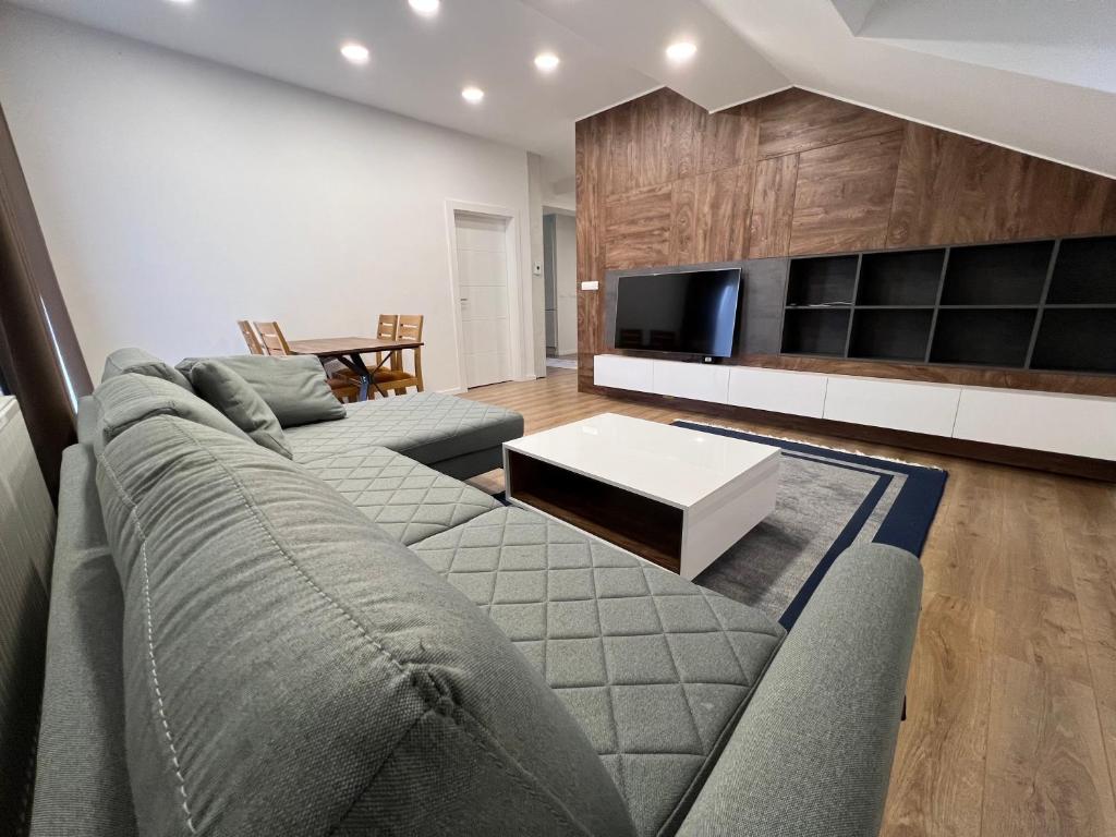a living room with a couch and a tv at Villa by Expert Aleja in Sarajevo