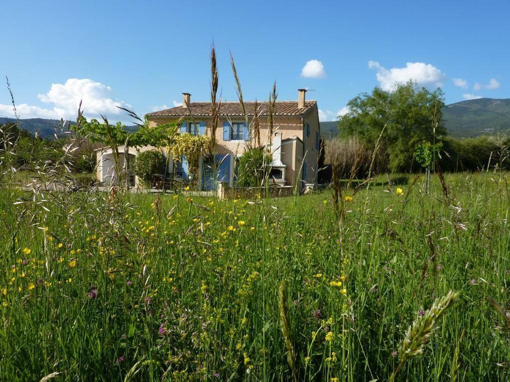 une maison au milieu d'un champ d'herbe dans l'établissement le Pijeonnier, à Bédoin