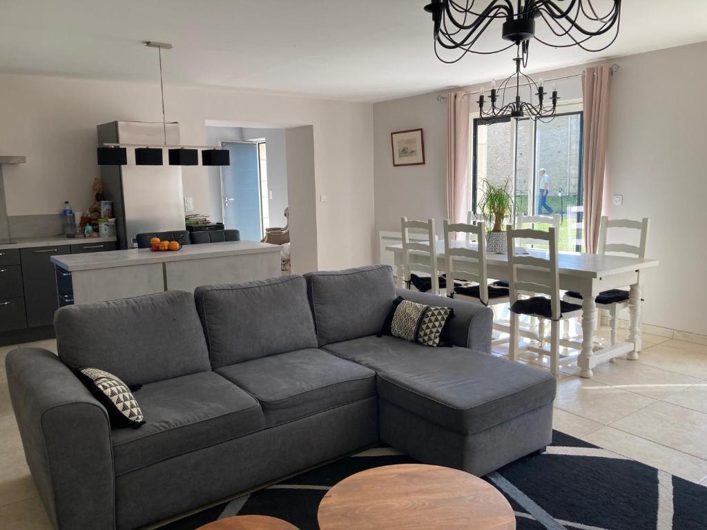 un salon avec un canapé et une salle à manger dans l'établissement LES HIRONDELLEs, à Courcy