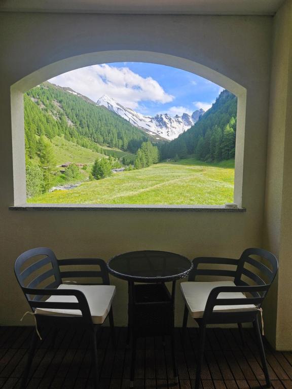 a table and chairs in a room with a window at Chasa Castello relax & spa in Samnaun