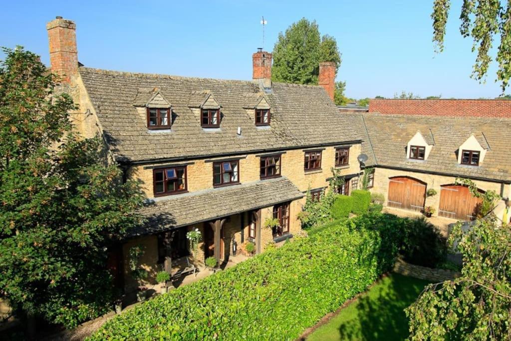 una grande casa con l'edera sul fianco di una collina di Lyne House Ideal for a celebration or reunion a Kidlington