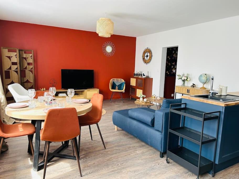 un salon avec une table et un canapé bleu dans l'établissement Cocon à 5 mn du circuit des 24h, au Mans