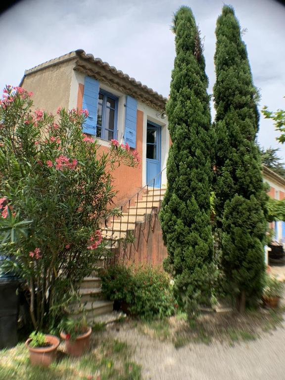 une maison avec deux grands arbres devant elle dans l'établissement Mas Valentine, à Roquemaure