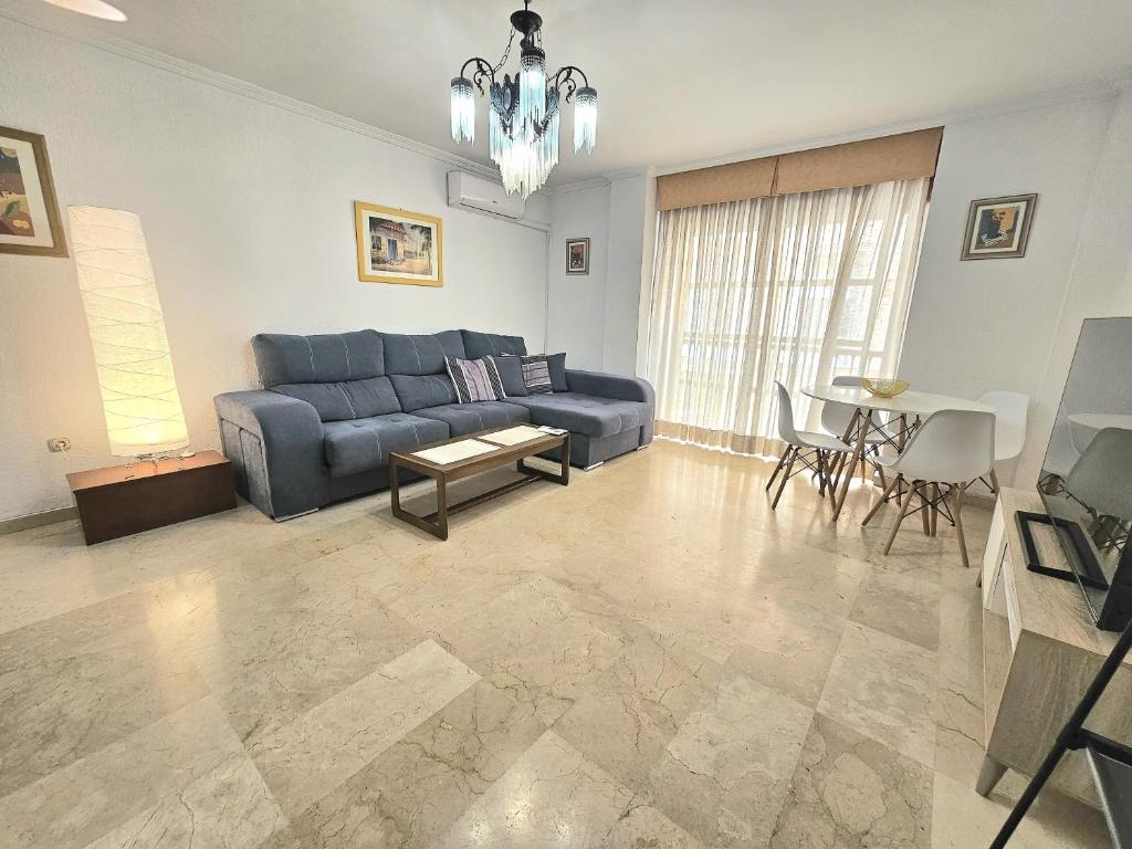 a living room with a blue couch and a table at ALMERIA CENTRO y CONFORT in Almería