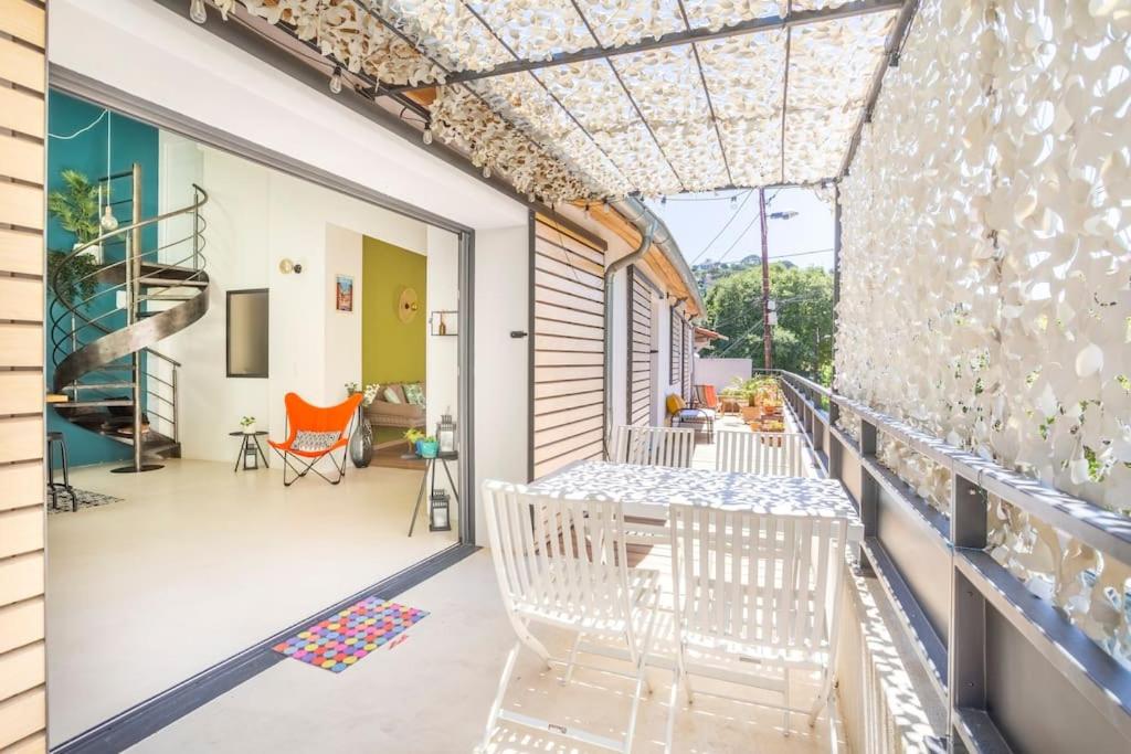 Cette maison dispose d'un balcon avec des chaises blanches. dans l'établissement Magnifique Villa d'Architecte - Terrasse & Parking - Les Frères de la Loc', à Marseille
