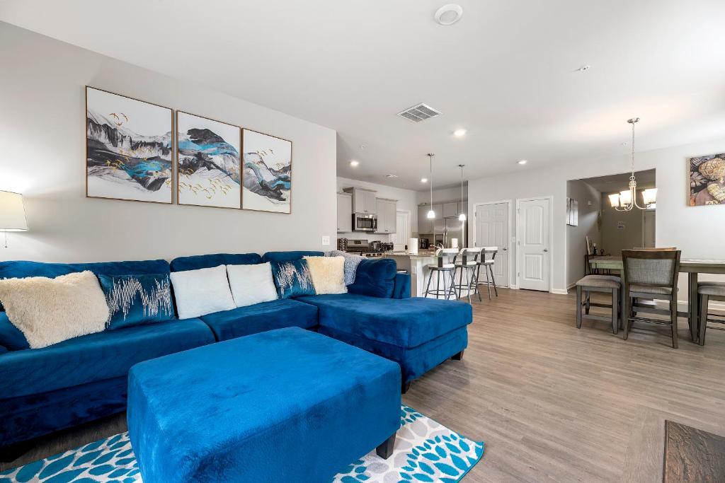 Una sala de estar con un sofá azul y una cocina. en Happy Hideaway by Deity Villas, en Atlanta