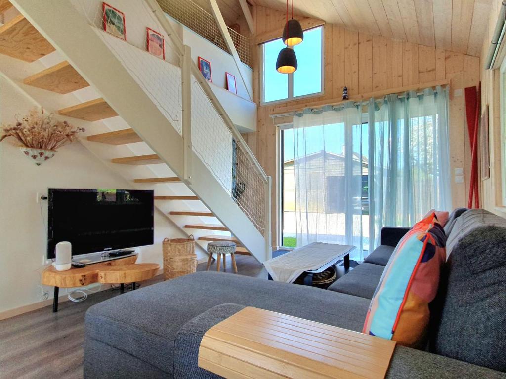 un salon avec un canapé et une télévision dans l'établissement Les Bonnes Ondes - Chalet breton bord de mer - Baie Mont St Michel, à Saint-Benoît-des-Ondes