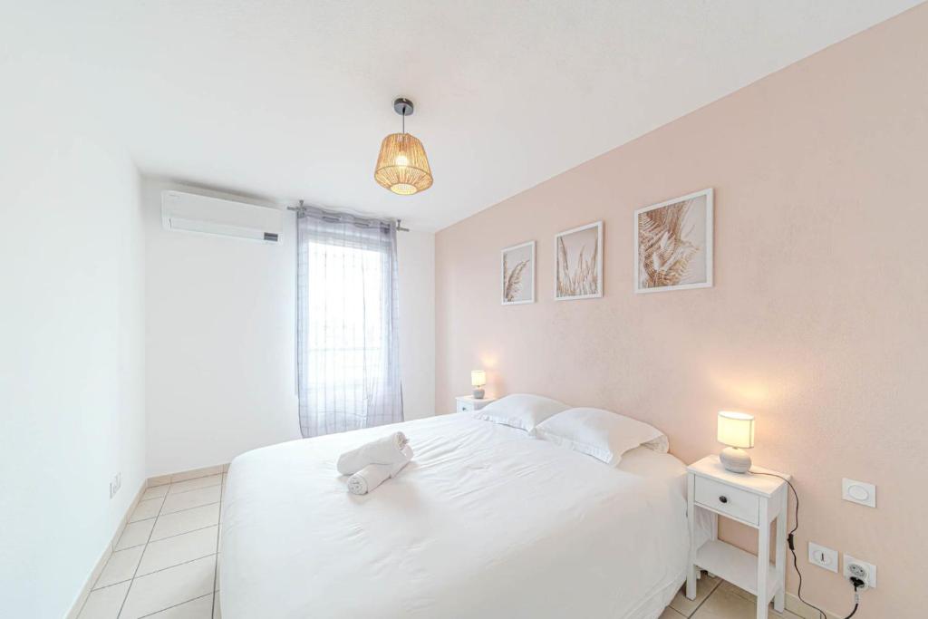 - une chambre blanche avec un grand lit blanc et deux lampes dans l'établissement Large bright apartment with balcony Villeurbanne, à Villeurbanne