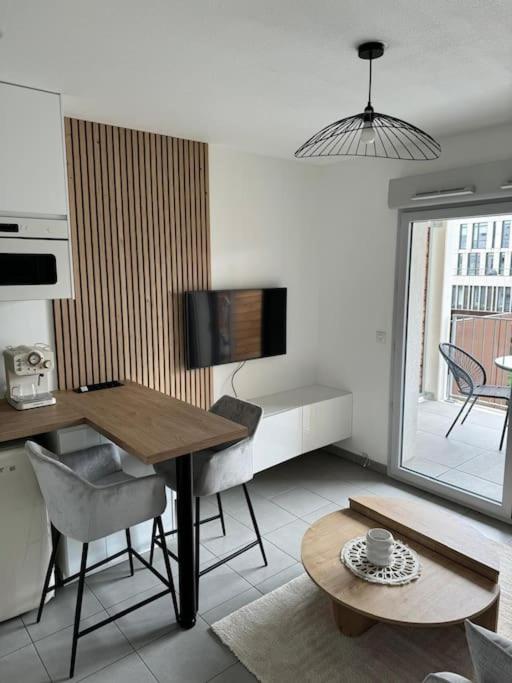 un salon avec une table et une télévision dans l'établissement L'escale Charmant Studio Villeurbanne La Soie, à Villeurbanne