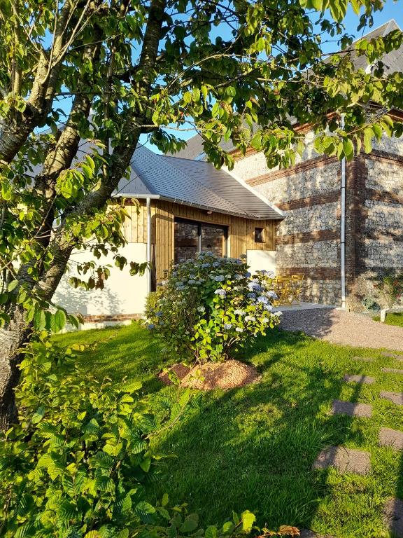 une maison avec un arbre dans la cour dans l'établissement Le Manège, à Thiétreville