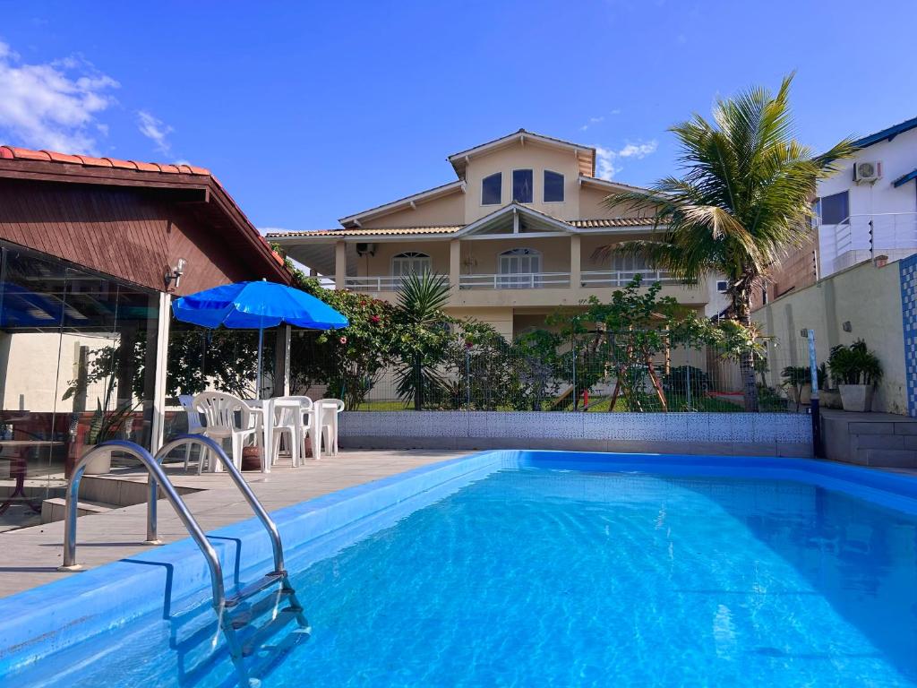 a swimming pool in front of a house at Hotel & Pousada Bella Vista in Florianópolis