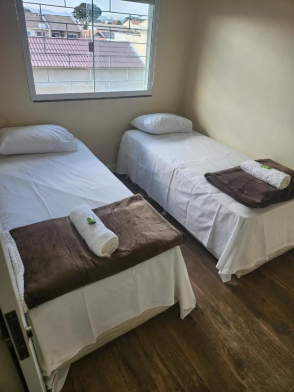 dwa łóżka w pokoju z oknem w obiekcie Ap completo proximo ao aeroporto w mieście São José dos Pinhais