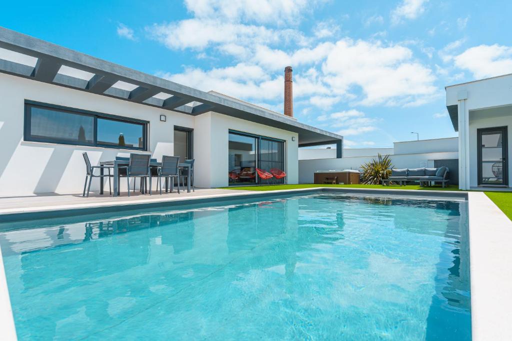 une piscine devant une maison dans l'établissement Villa Mauricio, à Mariquiteira