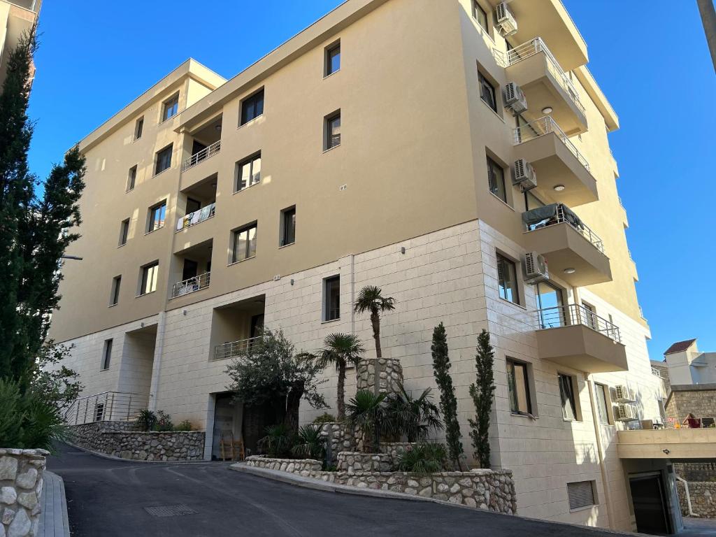 un immeuble avec des palmiers en face de celui-ci dans l'établissement Apartment Veljko Becici, à Becici