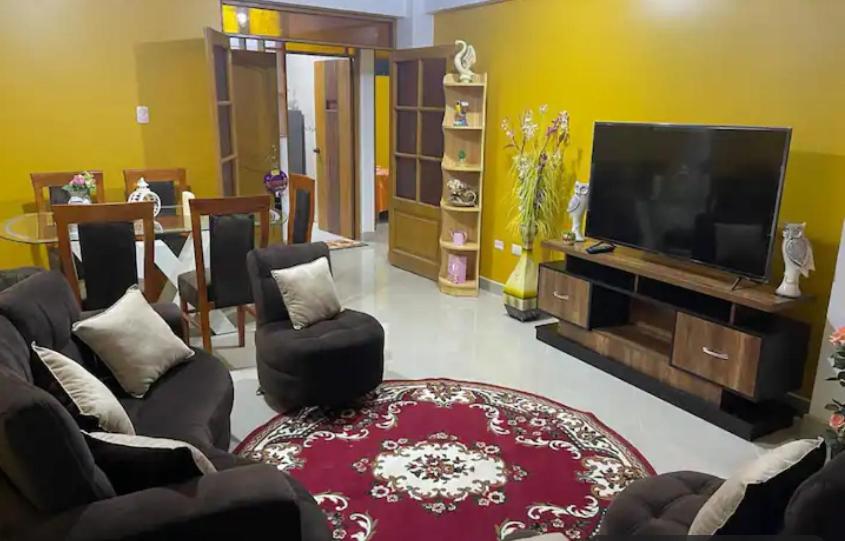 ein Wohnzimmer mit Flachbildfernseher und Stühlen in der Unterkunft D ROSSY House in Huaraz