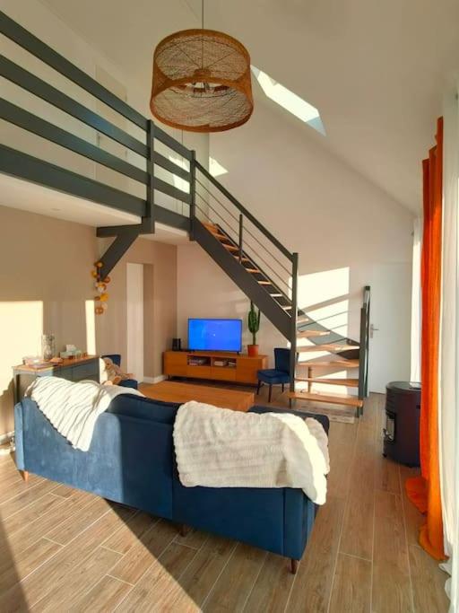 - une chambre avec un lit bleu et un escalier dans l'établissement Maison familiale bord de mer, à La Turballe
