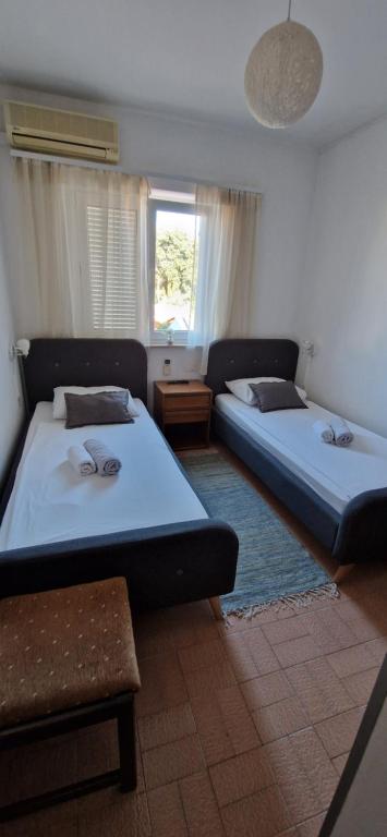 a bedroom with two beds and a window at Palute in Supetar