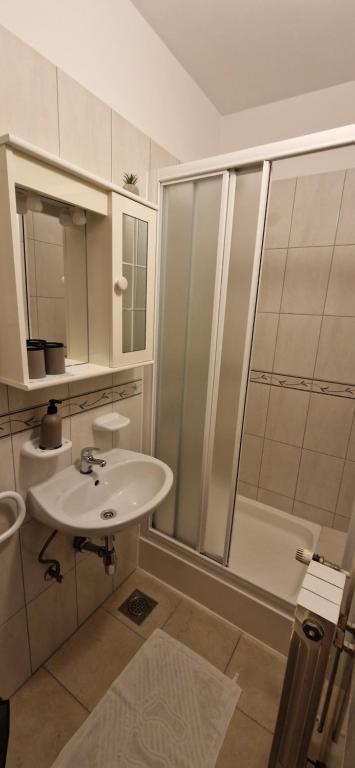 a white bathroom with a sink and a shower at Palute in Supetar