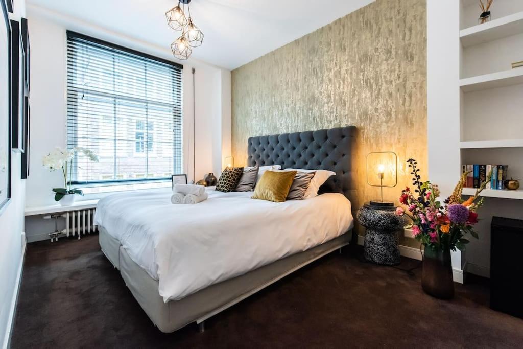 a bedroom with a large bed and a window at Luxurious boutique suite in City Center in Amsterdam
