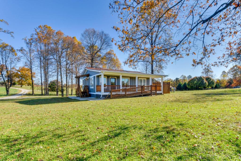 a house on a grassy field with a house at Modern Clarkesville Cottage with Decks and Patio! in Lakemont