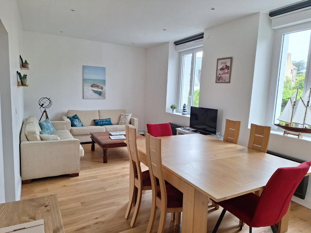 a living room with a wooden table and a couch at Appartement au cœur de la Côte de Granit Rose. in Trégastel