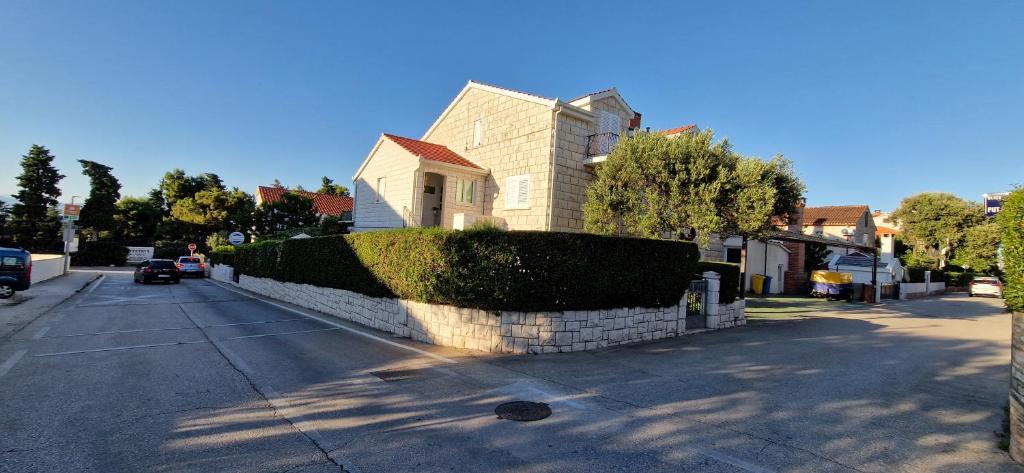 a house with a hedge in front of a street at Palute in Supetar
