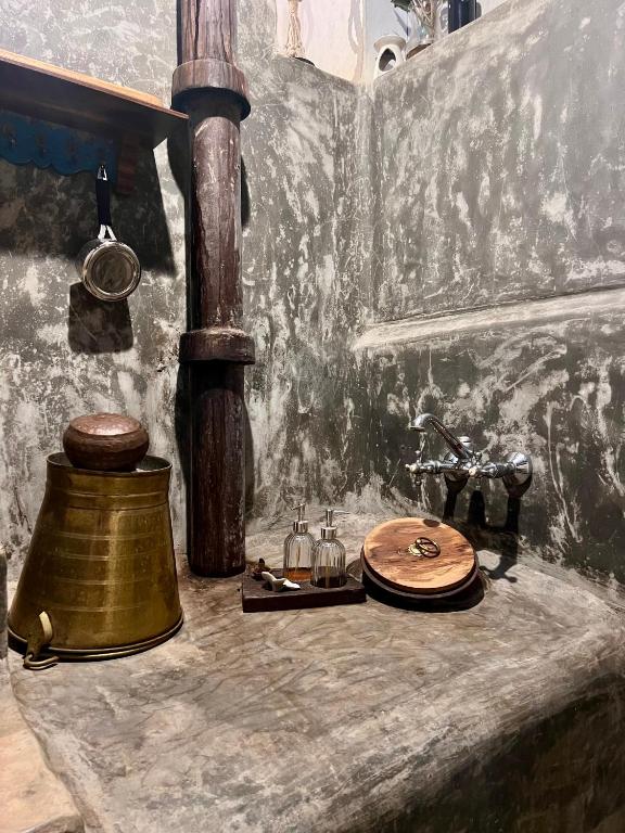a table with a copper bell and a sink at Svarna in Udupi